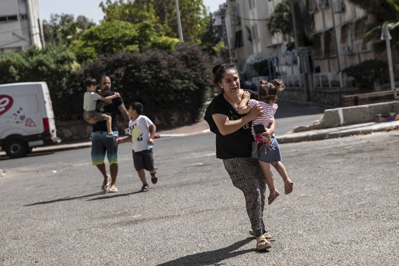 Lia Tal rushes with her children and partner to take shelter as a siren warns of incoming rockets in Ashdod, Israel, on May 20.