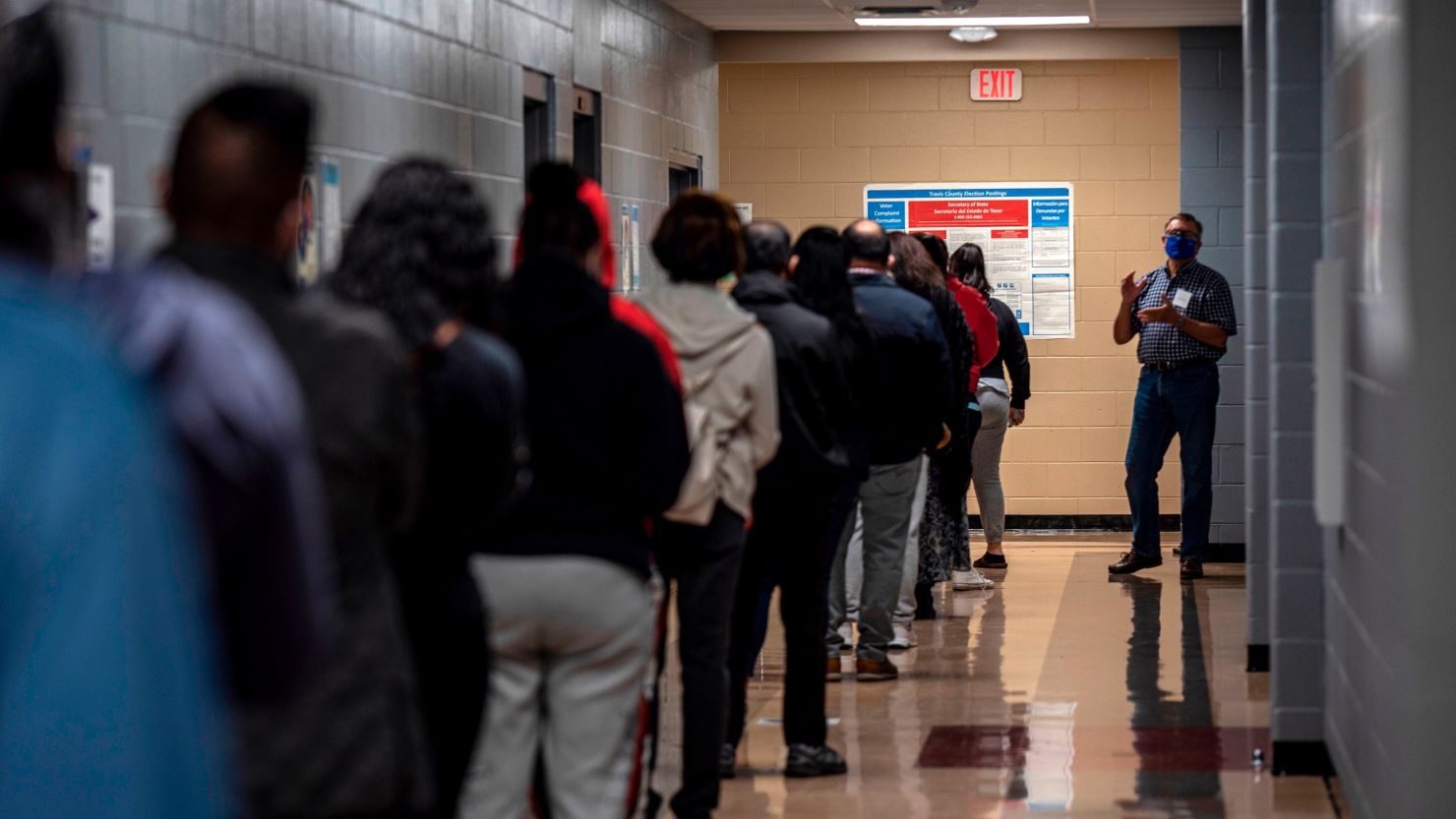 A poll worker talks to a line of voters on election day on November 3, 2020 in Austin, Texas. 