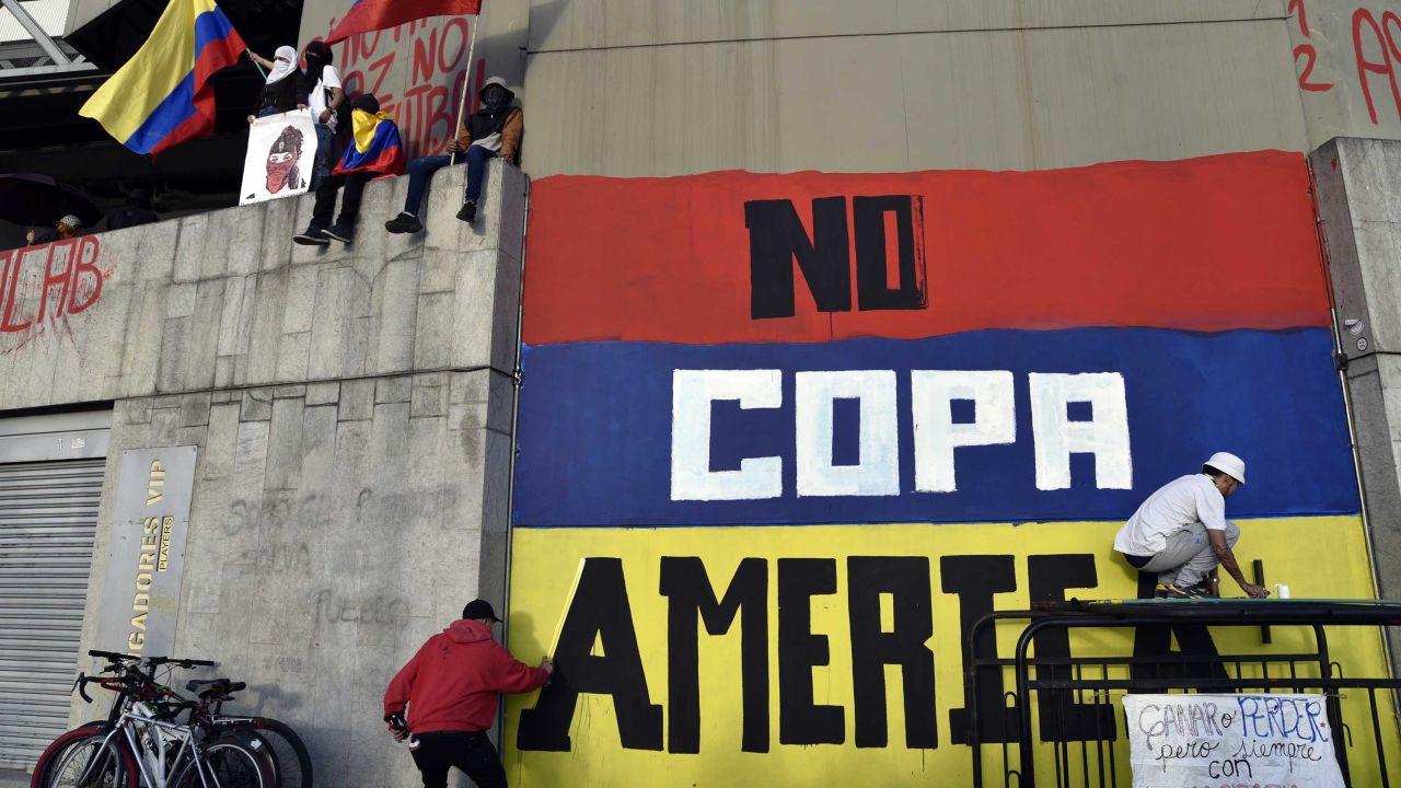 Street artists protest against Colombia hosting the Copa América on a wall of the Campin Stadium in Bogota on May 19.