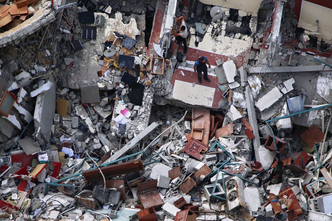 Palestinians inspect a destroyed building which housed media offices in Gaza City, after it was hit by an Israeli airstrike earlier in the week.