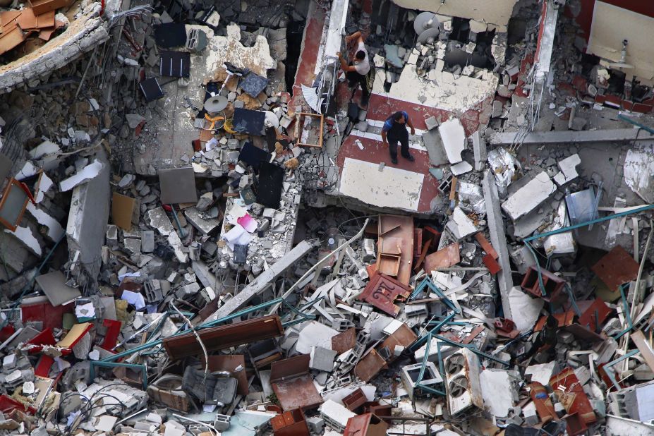 Palestinians inspect a destroyed building that housed media offices in Gaza City on Friday, May 21. It was hit by an Israeli airstrike earlier in the week.