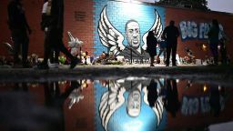 People stand in front of a mural of George Floyd in Houston, Texas on June 8, 2020. - George Floyd, the 46-year-old African American whose killing by a white police officer transformed him into a global icon of the struggle against racism and police brutality, will be laid to rest on June 9 in Houston, the city where he grew up. (Photo by Johannes EISELE / AFP) (Photo by JOHANNES EISELE/AFP via Getty Images)