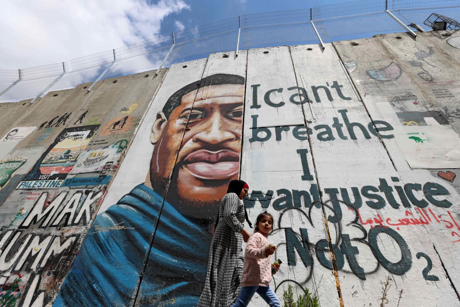 People walk past a Floyd mural in Bethlehem, West Bank, on March 31.