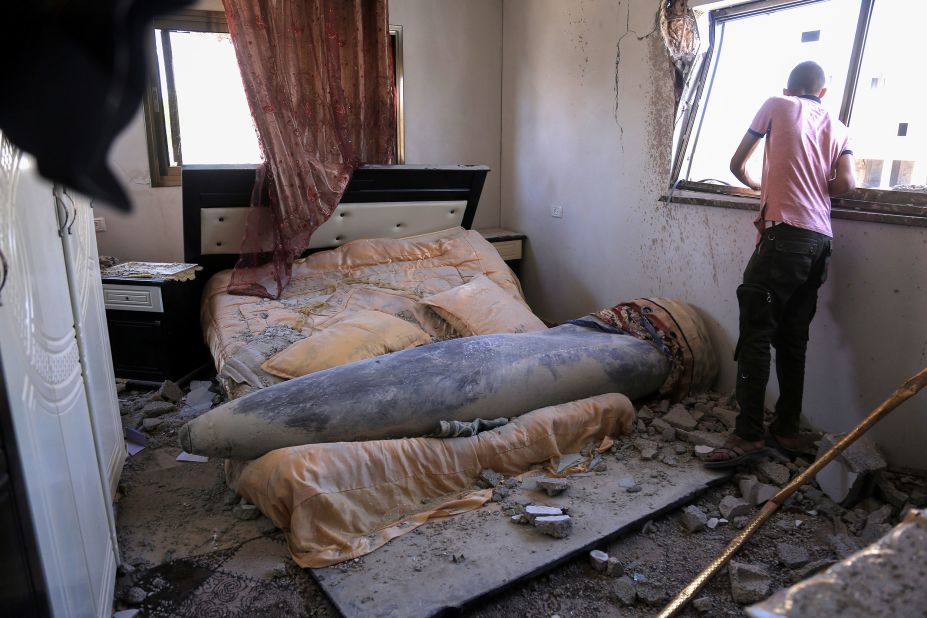 A young man looks out of a bedroom window where an unexploded Israeli missile landed in Khan Yunis, Gaza, on Thursday, May 20.