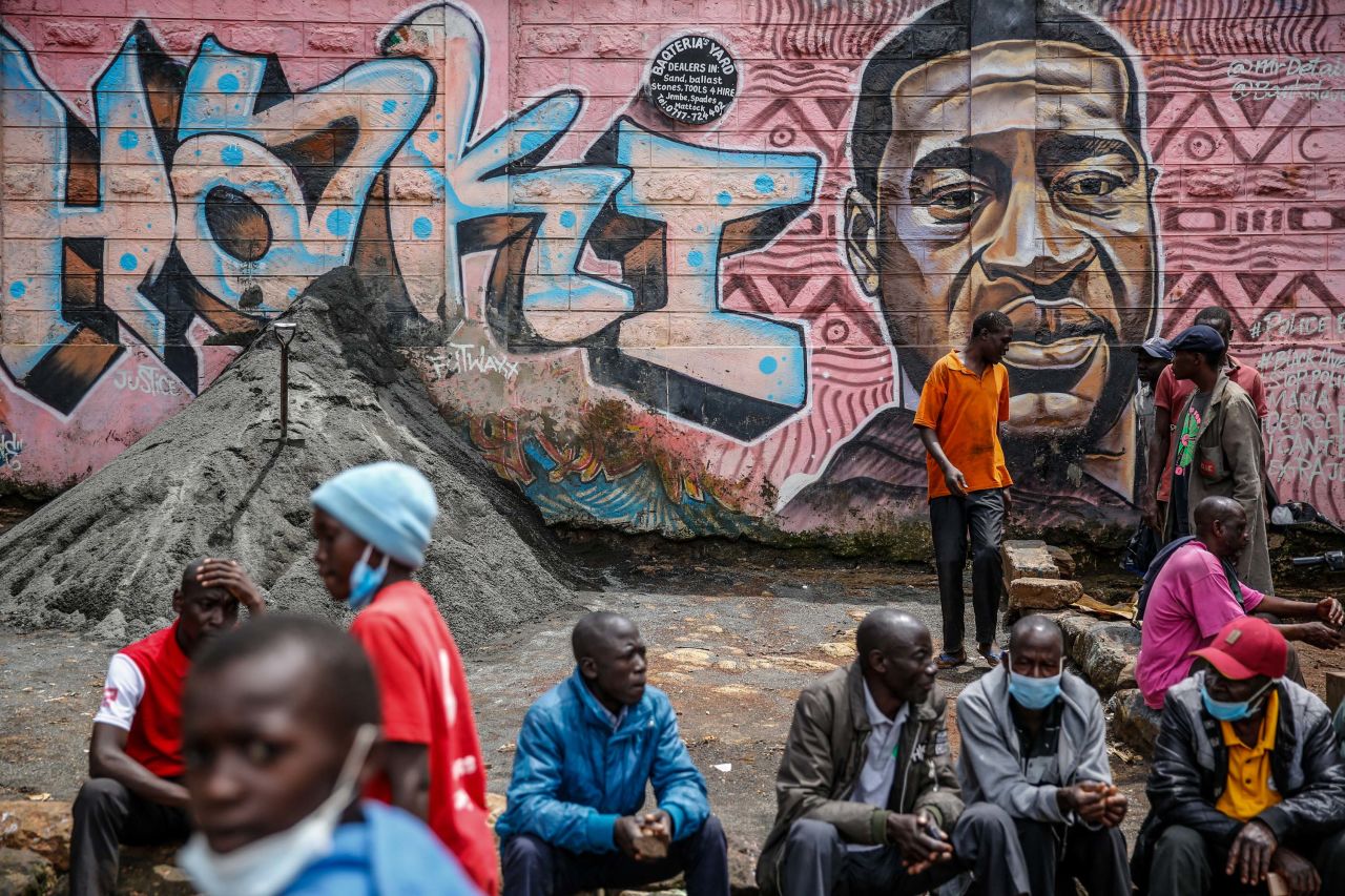 People in Nairobi, Kenya, sit near a Floyd mural on April 21. The Swahili word "haki" means "justice."