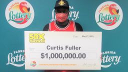 Curtis Fuller poses with an oversized check on May 17 after winning the 50X THE CASH scratch-off lottery game. He took home a lump-sum payment of $890,000.