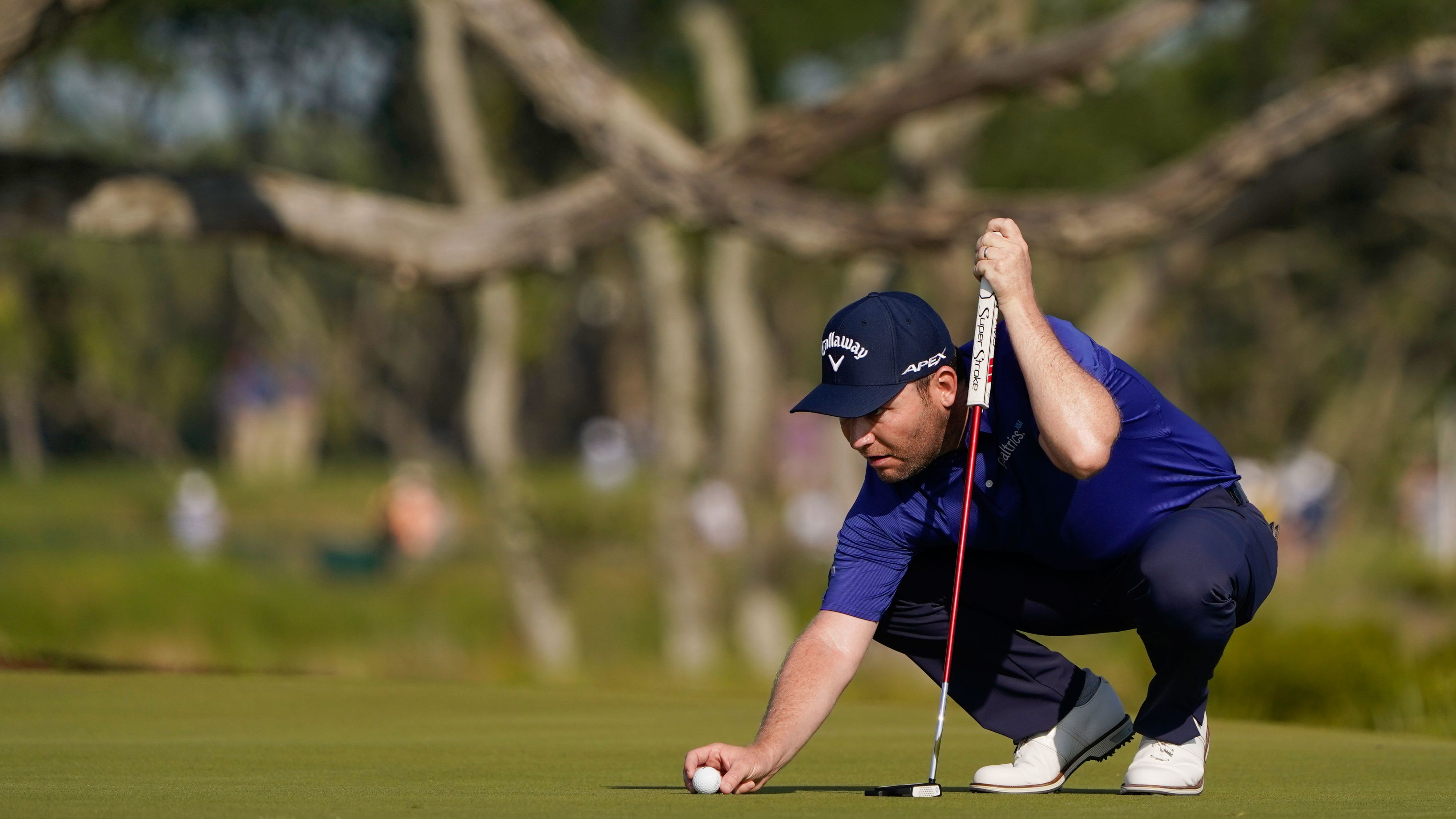 Branden Grace lines up a putt on the third hole.