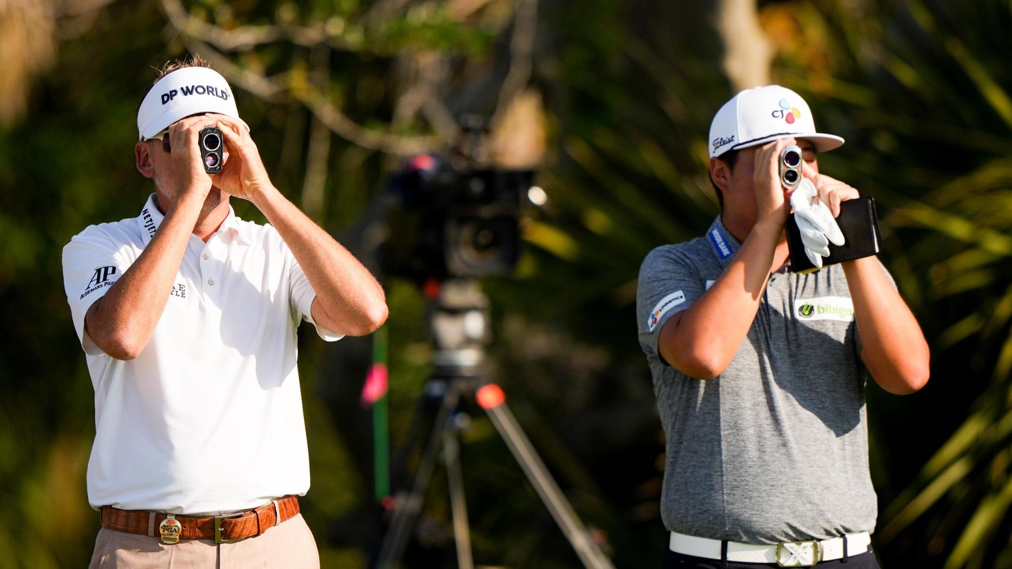 Ian Poulter and Sungjae Im read their yardage on the second hole.