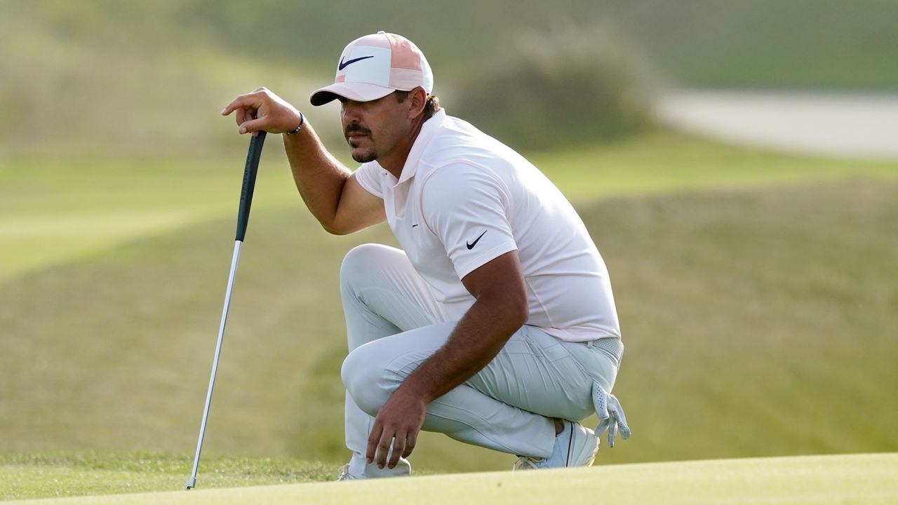 Koepka lines up a putt on the 16th green during the third round.
