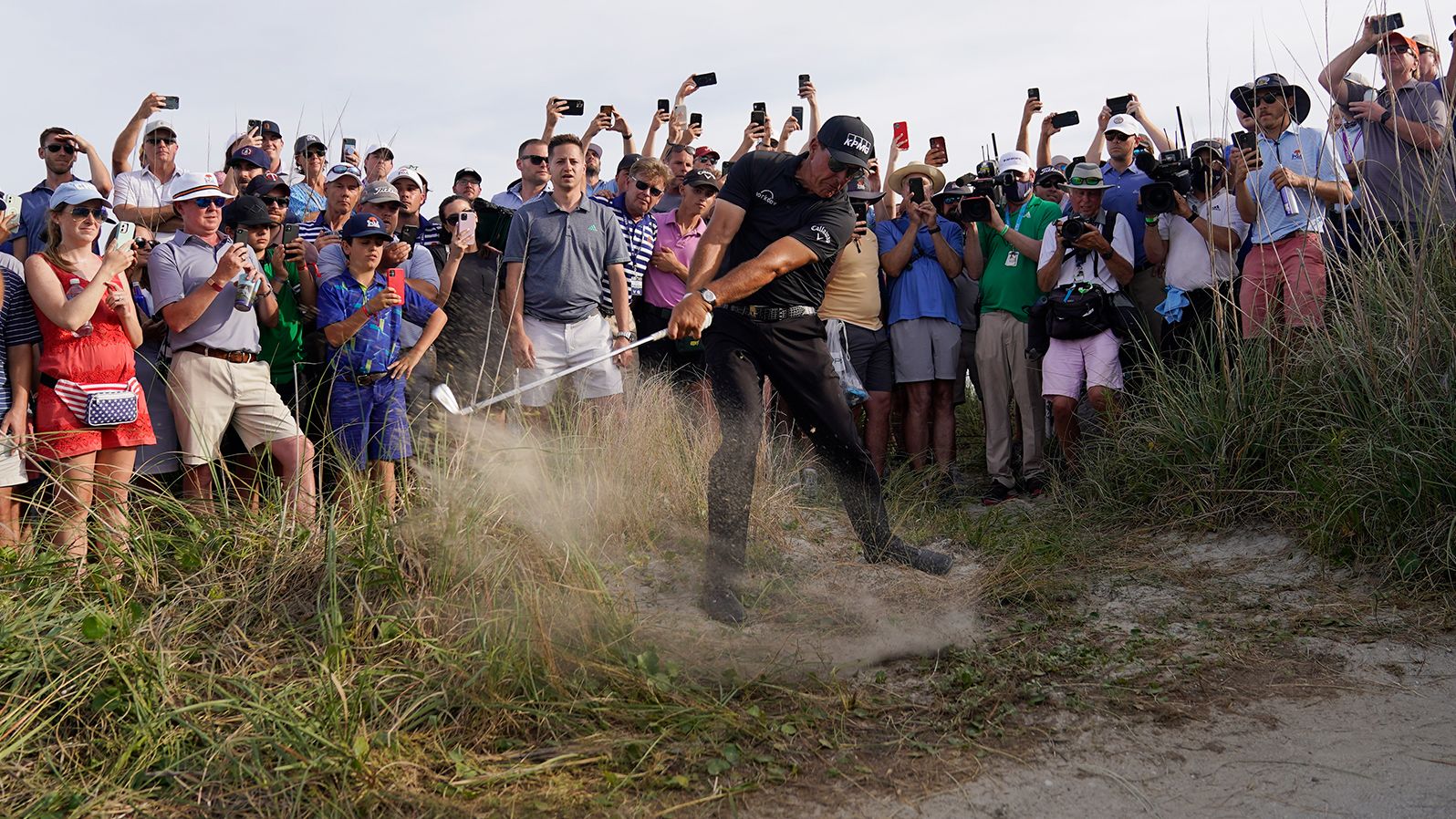 Phil Mickelson hits his second shot on the 16th hole surrounded by spectators on Saturday, May 22.
