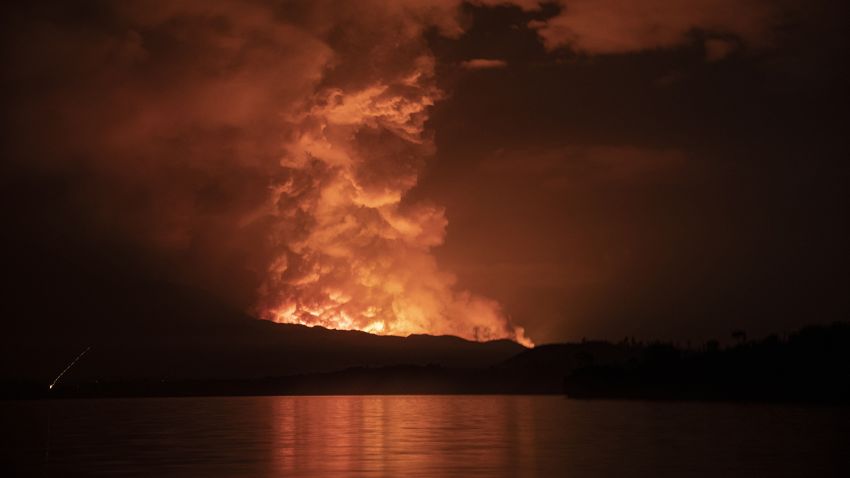 TOPSHOT - This general view taken on May 22, 2021 from Tchegera Island outsoide Goma on the lake Kivu in the East of the Democratic Republic of Congo shows flame spewing from the Nyiragongo volcano. - The famous Nyiragongo volcano, near the city of Goma, in the east of the Democratic Republic of the Congo (DRC), suddenly became active on Saturday evening, an AFP correspondent noted. Strong emanations of glowing light coming out of the crater were visible from Goma, while a smell of sulfur was perceptible in the city, located on the southern flank of the volcano, on the shores of Lake Kivu, he noted. (Photo by Alex Miles / AFP) (Photo by ALEX MILES/AFP via Getty Images)