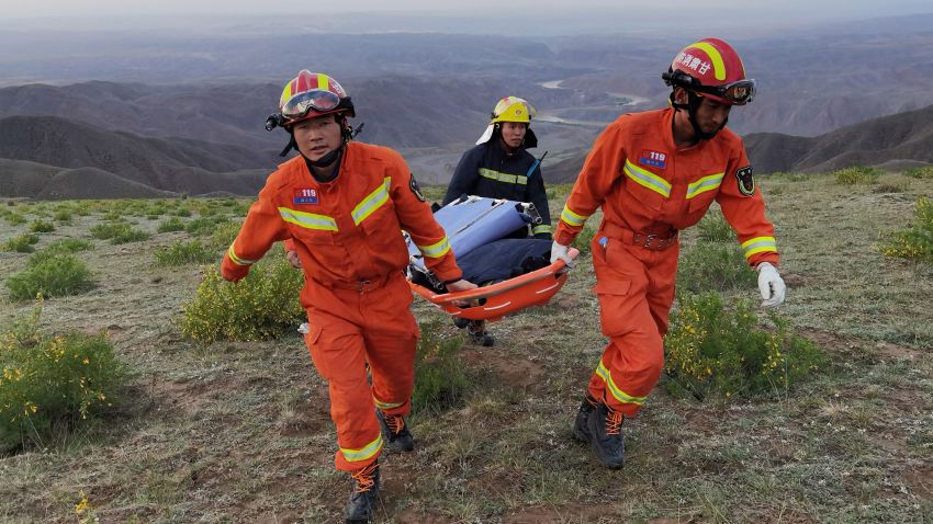 This photo taken on May 22, 2021 shows rescuers carrying equipment as they search for runners who were competing in a 100-kilometre cross-country mountain race when extreme weather hit the area, leaving at least 20 dead, near the city of Baiyin in China's northwestern Gansu province. - China OUT (Photo by STR / AFP) / China OUT (Photo by STR/AFP via Getty Images)