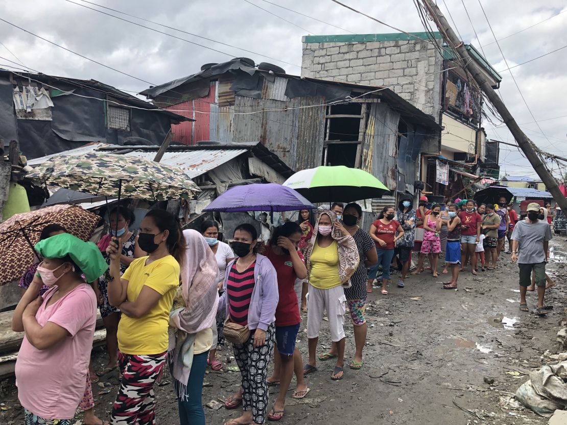 People queue for food at a community kitchen in Manila.