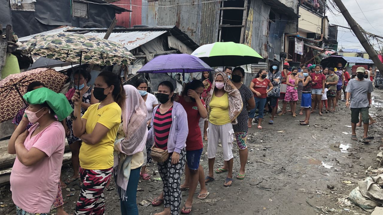 People queue for food at a community kitchen in Manila.