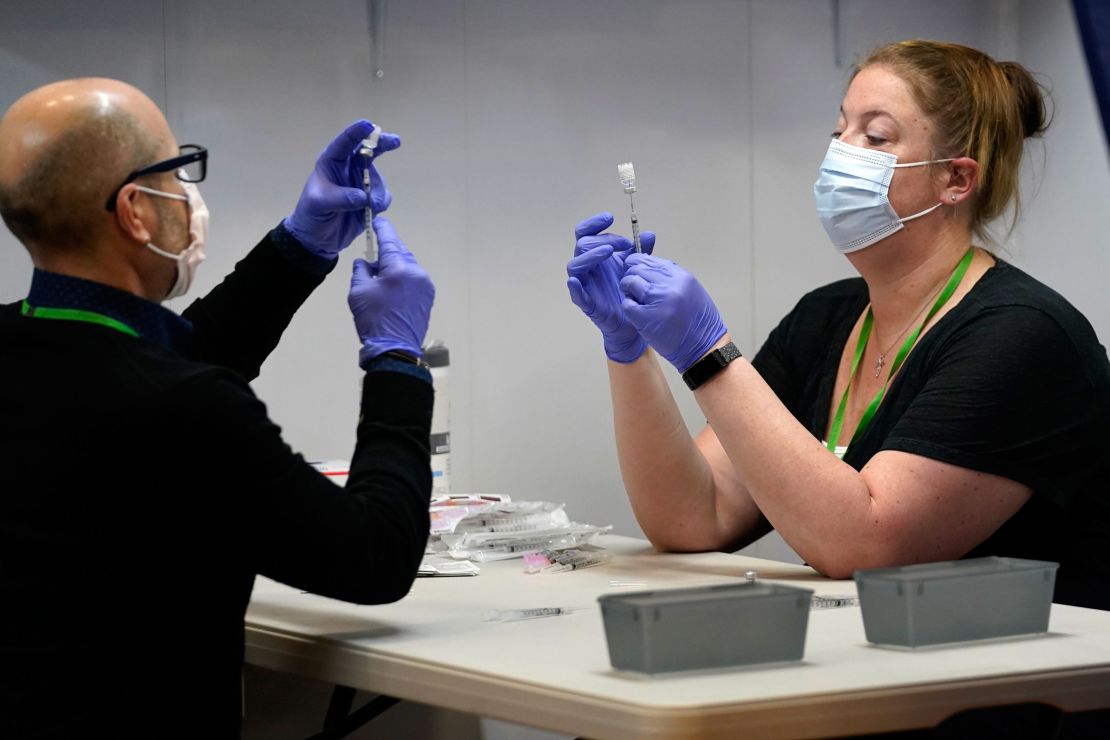 Pharmacy technicians fill syringes with Pfizer's Covid-19 vaccine March 2 at the Portland Expo in Portland, Maine.