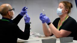 Nick Bloom, left, and Hollie Maloney, pharmacy technicians, fill syringes with Pfizer's COVID-19 vaccine, Tuesday, March 2, 2021, at the Portland Expo in Portland, Maine. The Expo location, operated by Northern Light Health, is one of two mass vaccination sites that opened in Maine this week. (AP Photo/Robert F. Bukaty)