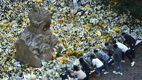 People present flowers around a statue of agronomist Yuan Longping in Chongqing, China, following his death on Saturday.