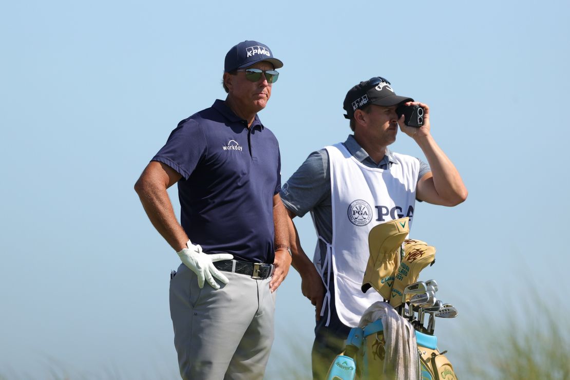Mickelson looks on from the eighth tee with his caddie and brother Tim during the final round.