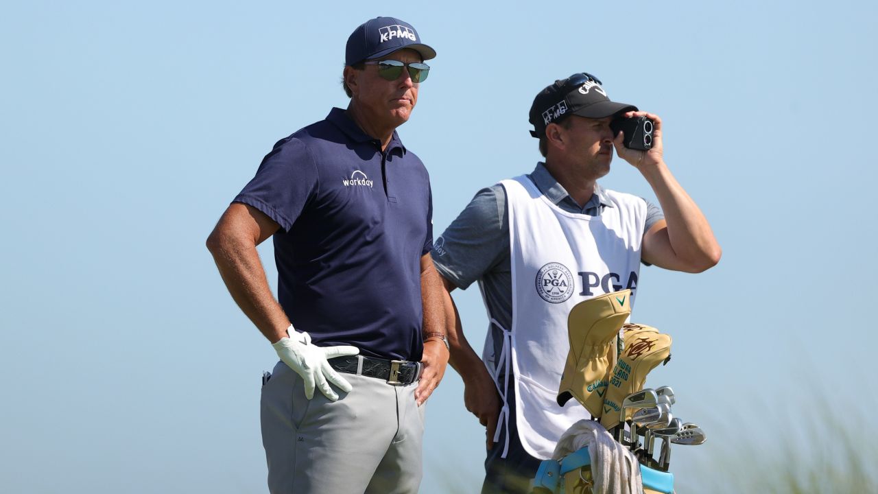 Mickelson looks on from the eighth tee with his caddie and brother Tim during the final round.