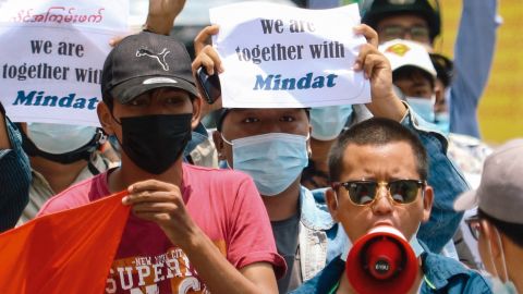 Protesters hold signs in support of the town of Mindat in Chin state, during a demonstration in Mandalay on May 17.