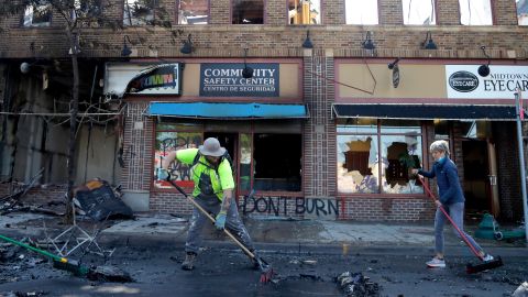 People help cleanup near businesses damaged by protesters on May 30, 2020, in Minneapolis.