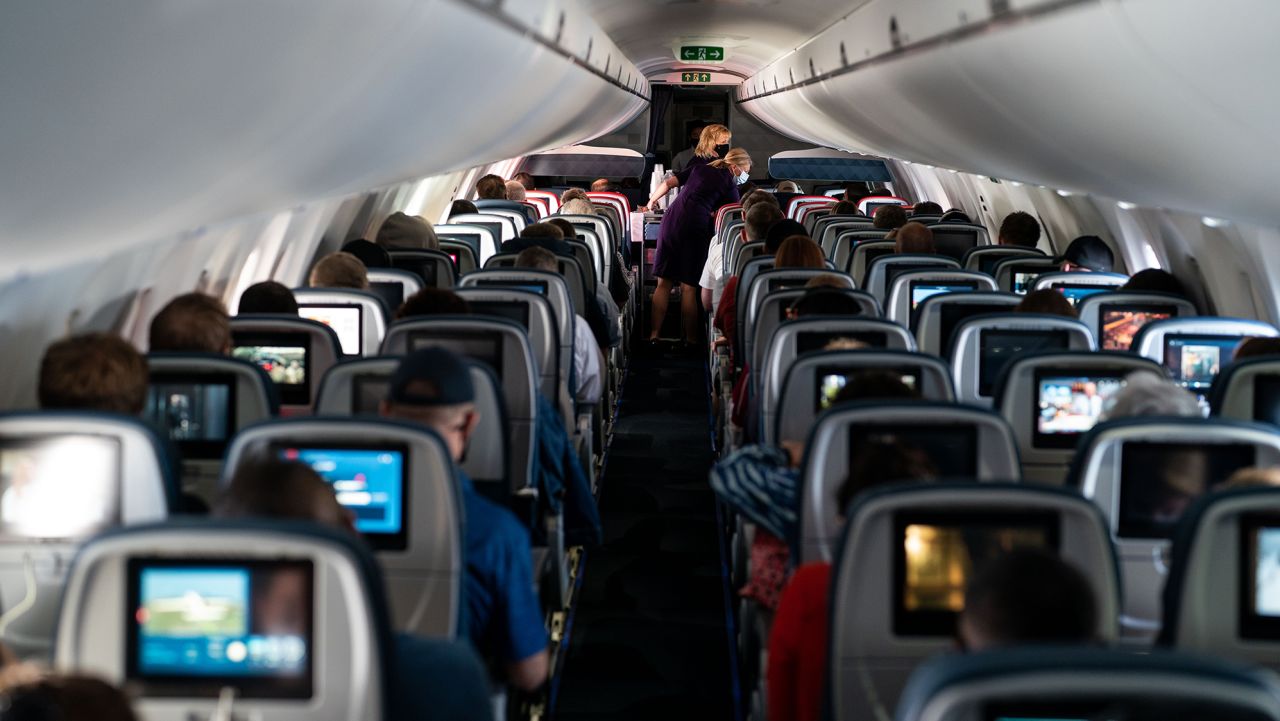 Flight attendants hand out refreshments to a packed Delta Airlines flight traveling from Ronald Regan National Airport to Minneapolis Saint Paul International Airport on Friday, May 21, 2021.