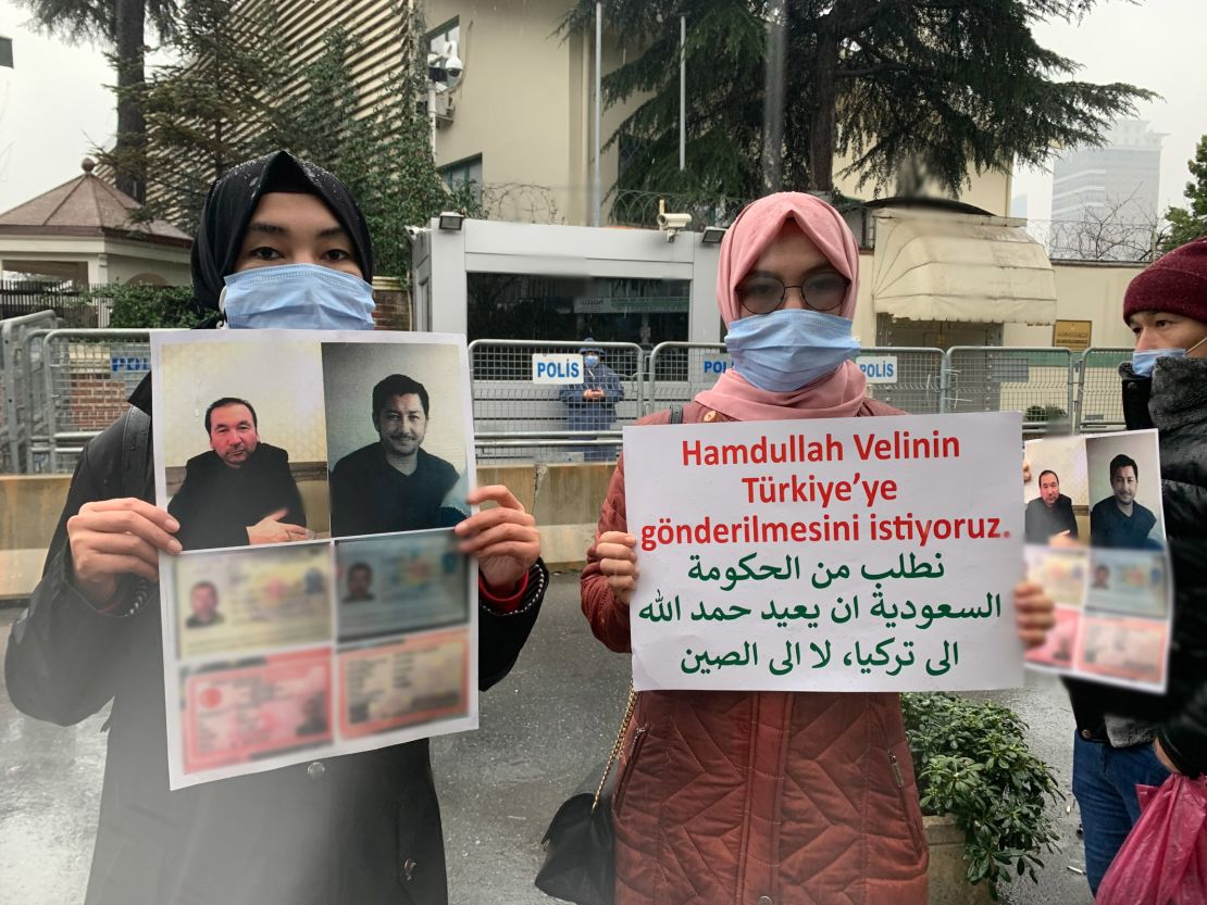Nuriman Veli, second from left, and her sister protesting the disappearance of their father and his friend, pictured on the placard, outside Istanbul's Saudi consulate on February 12. CNN has blurred a portion of the photo to protect the men's personal details.