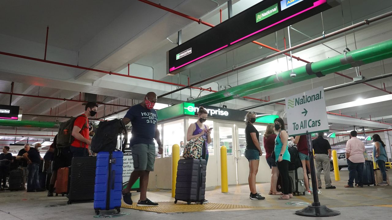People wait in line at Enterprise rental agency in the Miami International Airport Car Rental Center in April 2021 in Florida. 