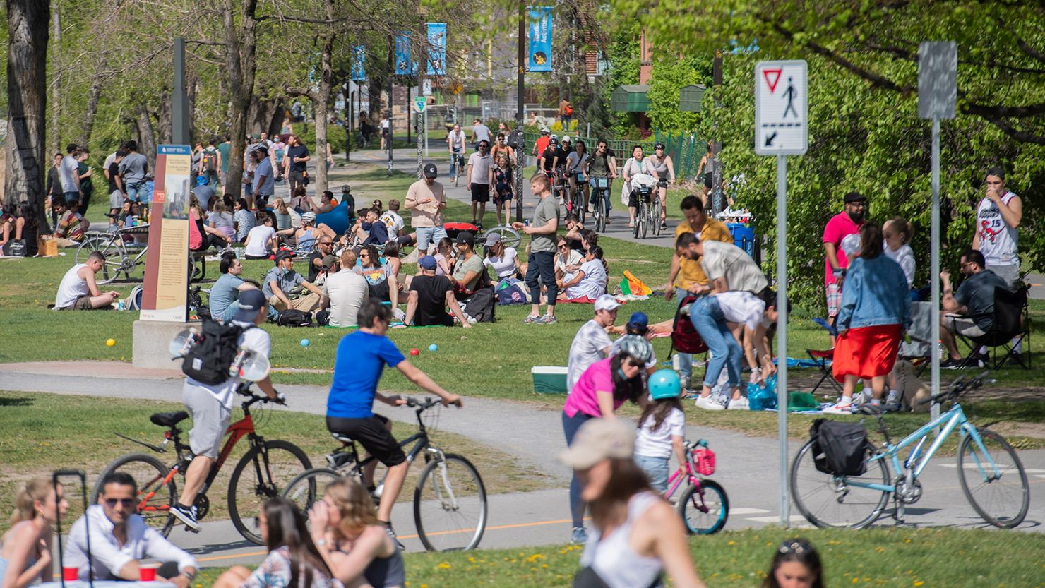 People gather next to the Lachine Canal on a warm spring day in Montreal, Saturday, May 15, 2021.