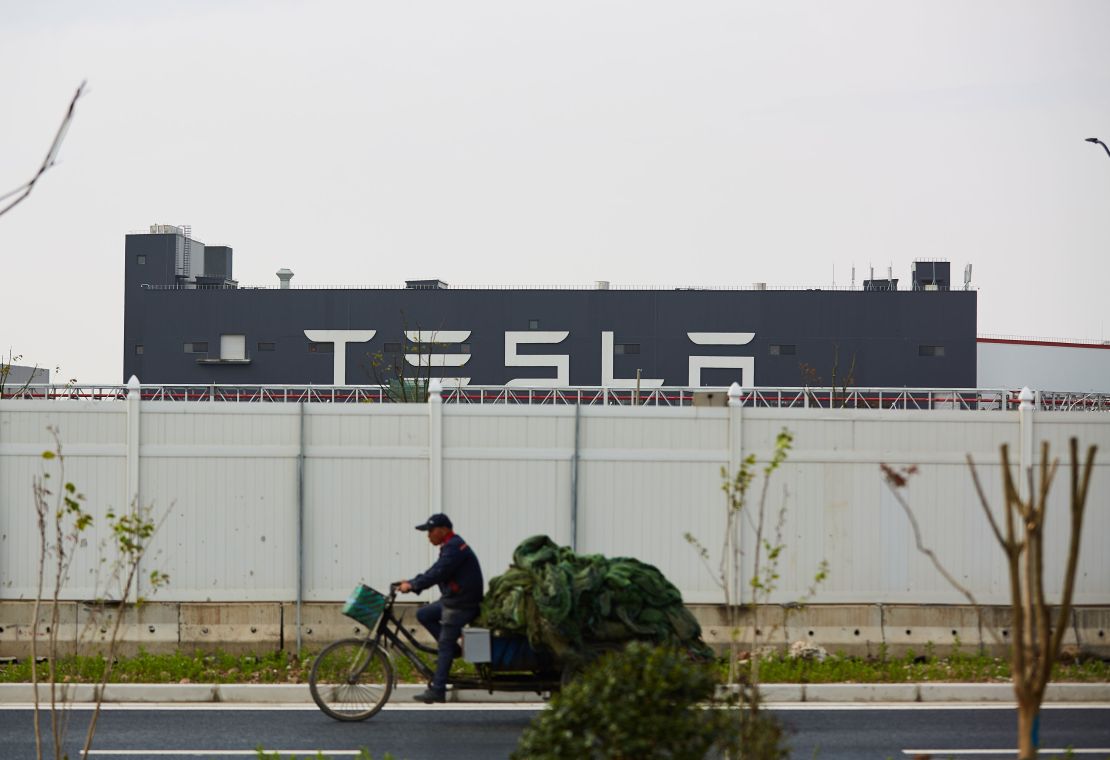 A man riding a tricycle past Tesla's Shanghai Gigafactory on April 25.