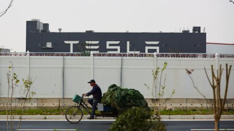 A man riding a tricycle past Tesla's Shanghai Gigafactory on April 25.