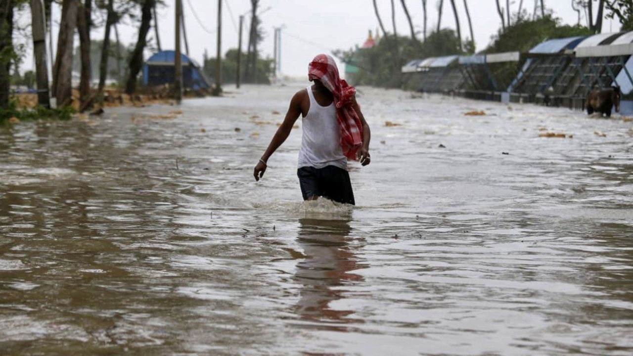 A man wades through a waterlogged road after rains ahead of Cyclone Yaas in Purba Medinipur, West Bengal, India, on May 26.