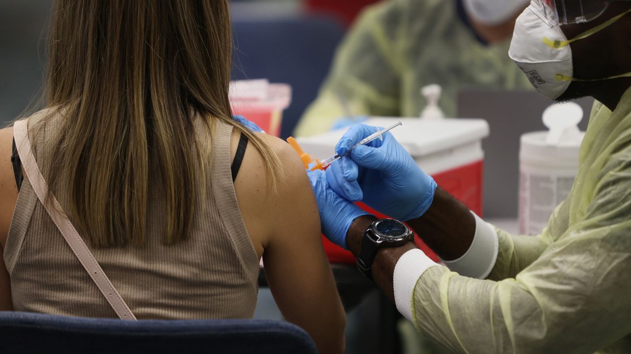 Sara Kalinicos, from Peru, receives the Pfizer-BioNtech vaccine from a healthcare worker at Miami International Airport on May 10.