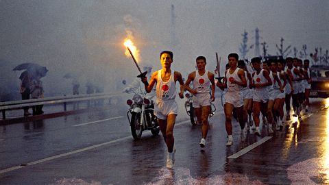 Torchbearers run through the rain on their way to the National Stadium in Tokyo in October 1964.