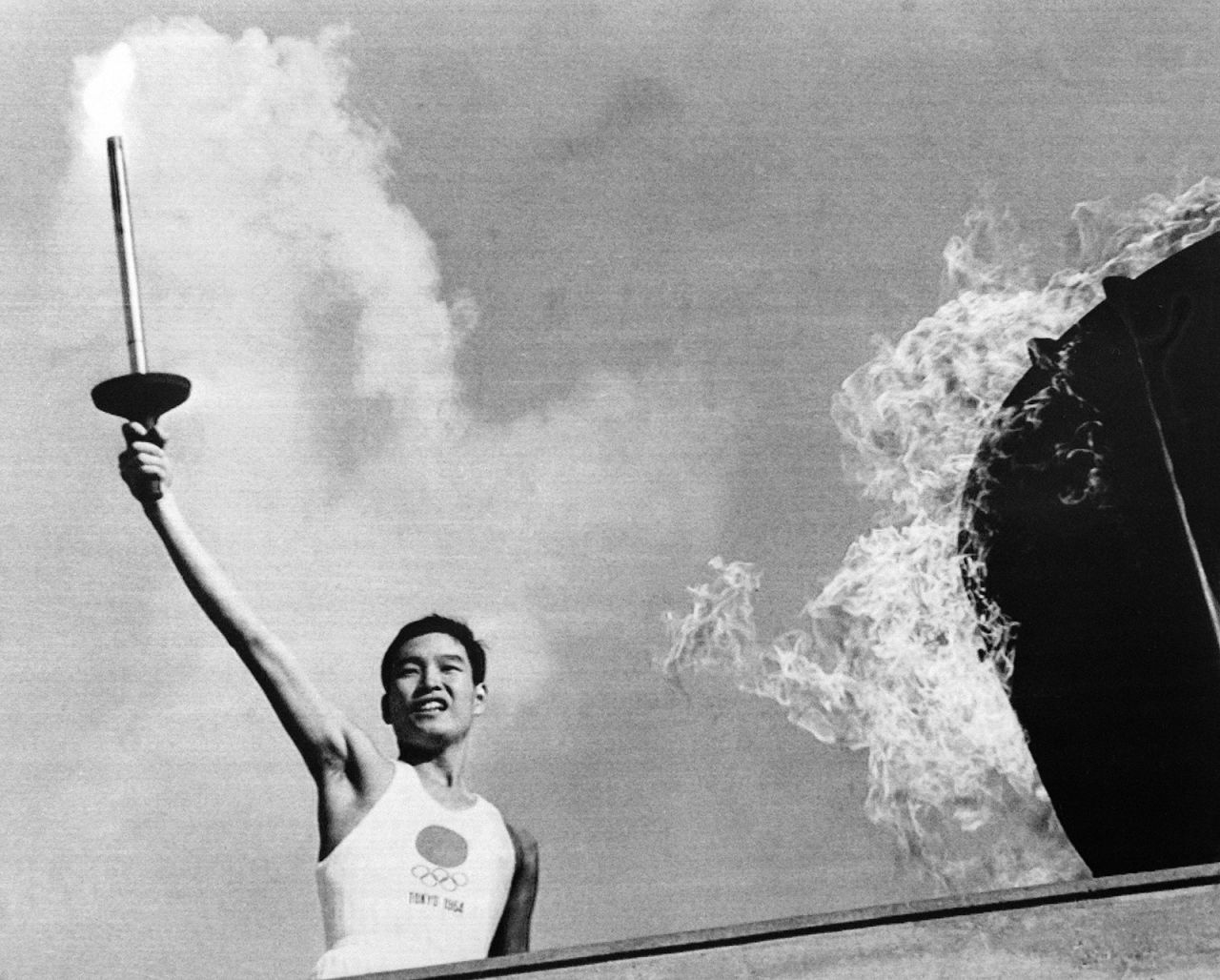 Yoshinori Sakai carries the torch up the stairs to light the Olympic cauldron during the opening ceremony. Sakai was born in Hiroshima, Japan, on the day the first atomic bomb devastated the city,
