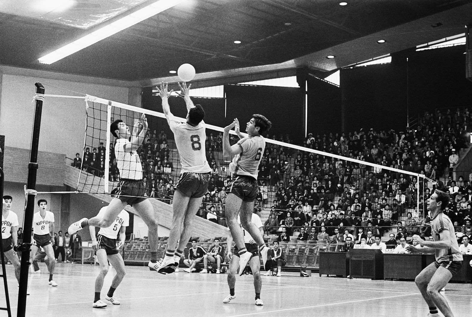 Japanese volleyball player Terushia Moriyama, left, has his spike blocked by Brazil's Ramalho Oliveira (No. 8) and Marco Antonio Volpi.