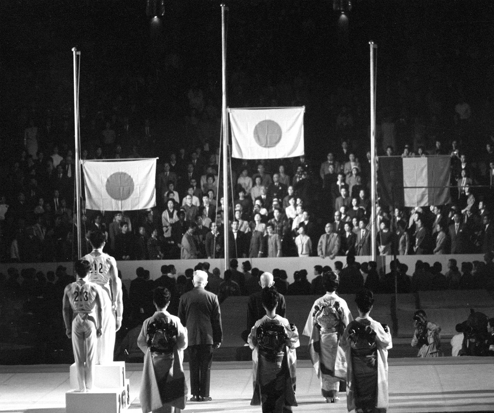 Flags are raised during an award ceremony for a men's gymnastics event. Japan's Yukio Endo won the parallel bars. Shuji Tsurumi won silver, and Italy's Franco Menichelli won bronze.