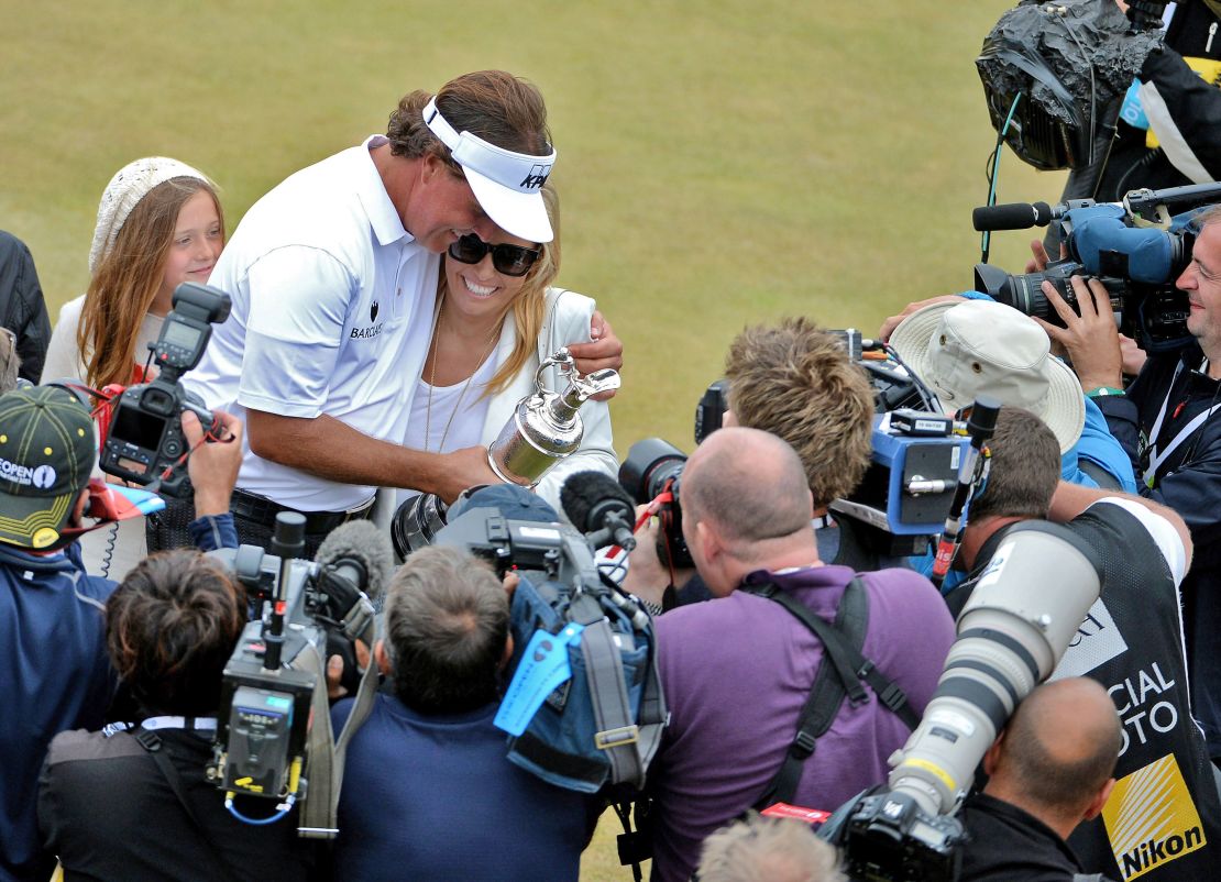 Mickelson holds the Claret Jug with wife Amy after winning the 142nd Open Championship at Muirfield in 2013.