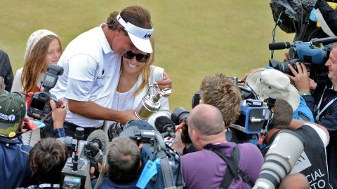 Mickelson holds the Claret Jug with wife Amy after winning the 142nd Open Championship at Muirfield in 2013.