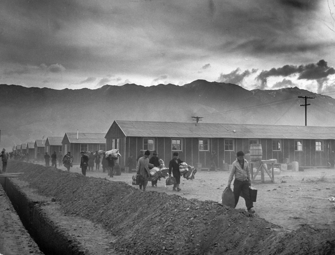 The first group of 82 Japanese-Americans arrive at the Manzanar internment camp (or 'War Relocation Center') carrying their belongings in suitcases and bags in 1942. 