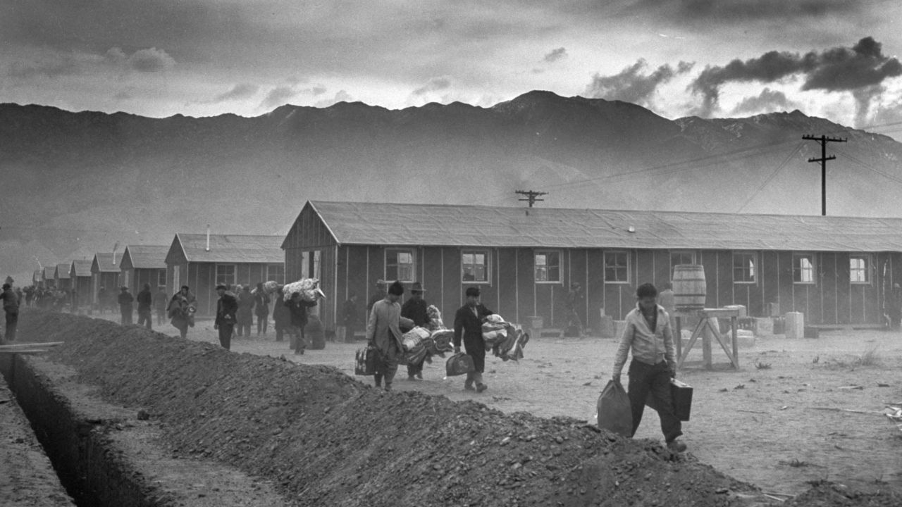 The first group of 82 Japanese-Americans arrive at the Manzanar internment camp (or 'War Relocation Center') carrying their belongings in suitcases and bags in 1942. 