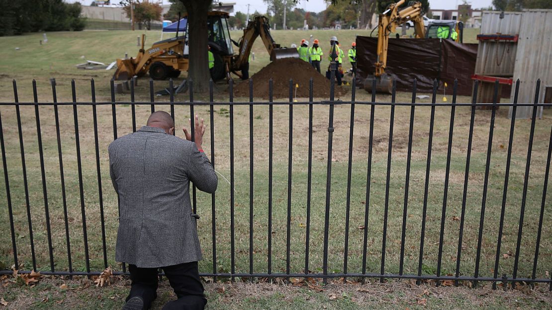 Rev. Robert Turner, with Vernon A.M.E Church, prays as crews work on a second test excavation and core sampling, Tuesday, Oct. 20, 2020, in the search for remains at Oaklawn Cemetery in Tulsa, Okla., from the 1921 Tulsa Race Massacre.