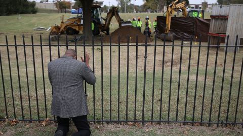 Rev. Robert Turner, with Vernon A.M.E Church, prays as crews work on a second test excavation and core sampling, Tuesday, Oct. 20, 2020, in the search for remains at Oaklawn Cemetery in Tulsa, Okla., from the 1921 Tulsa Race Massacre.
