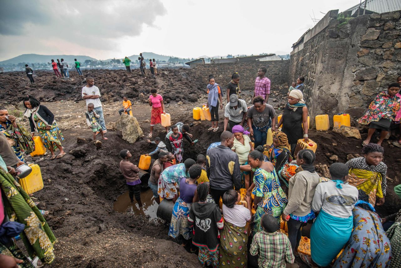 Locals gather around a water point at a lava-covered field in Goma on May 25.