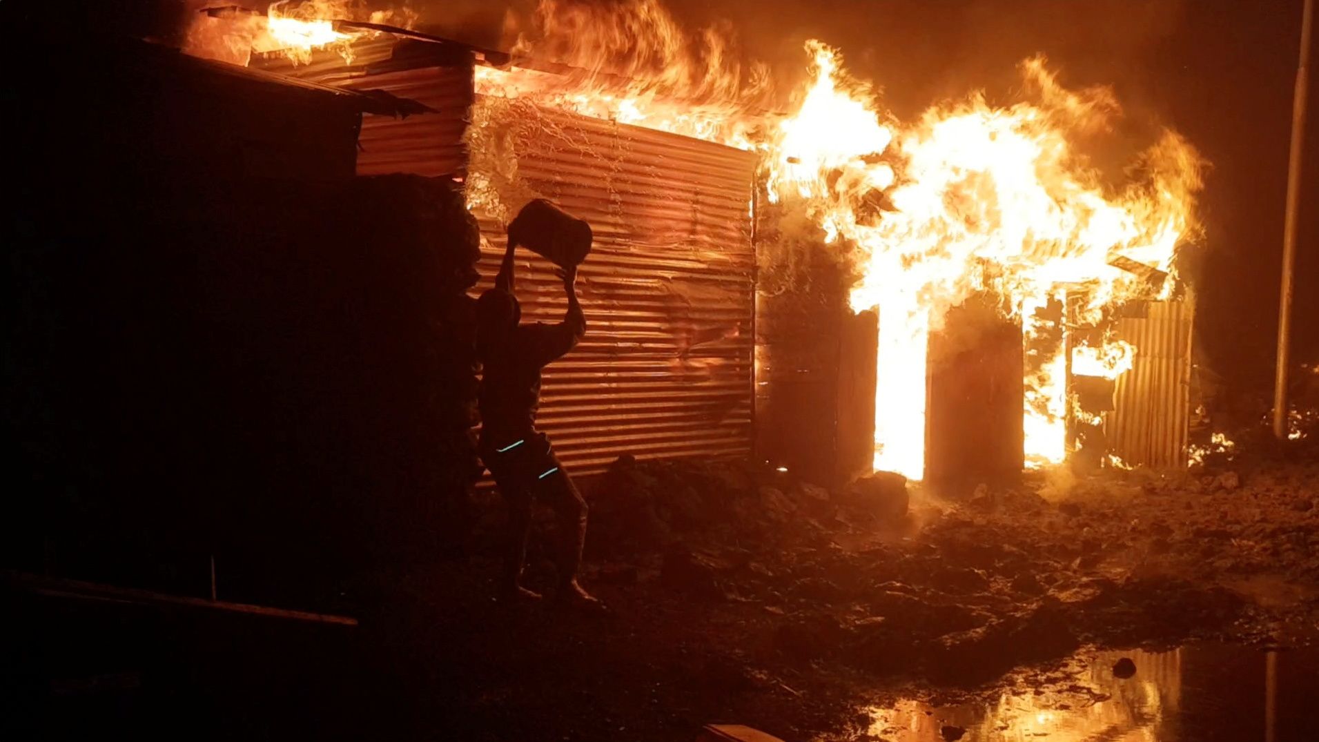 A person tries to put out a fire in Goma after the volcano's eruption on May 22.
