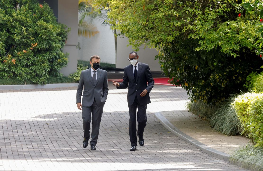 France's President Emmanuel Macron (L) and Rwanda's President Paul Kagame speak as they walk in the grounds of The Presidential Palace in Kigali on May 27, 2021.