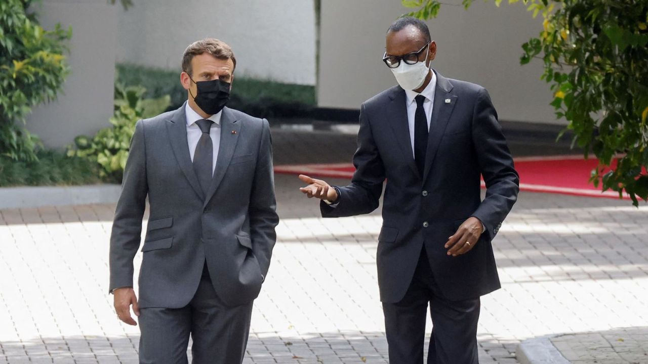 France's President Emmanuel Macron (L) and Rwanda's President Paul Kagame speak as they walk in the grounds of The Presidential Palace in Kigali on May 27, 2021.