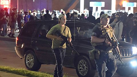 Kyle Rittenhouse, left, with backwards cap, in Kenosha, Wisconsin, with another armed civilian during chaotic protests in August 2020 over the police shooting of Jacob Blake, a Black man. Rittenhouse is accused of killing two people during the protests.