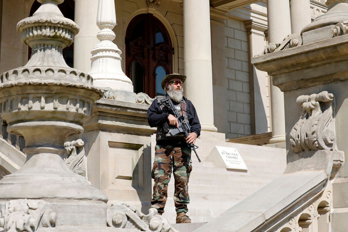 An armed demonstrator attends a rally in support of First Amendment rights  at the Michigan State Capitol in Lansing on May 15, 2021. 