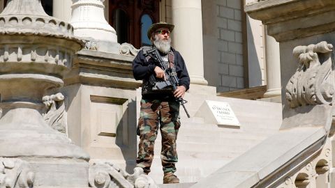 An armed demonstrator attends a rally in support of First Amendment rights  at the Michigan State Capitol in Lansing on May 15, 2021. 